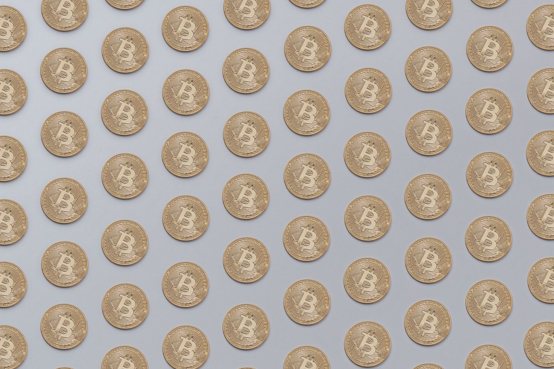 High-resolution image of golden Bitcoin coins arranged in a seamless pattern, ideal for financial or technological themes.